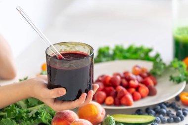 Bir bardak meyve suyu, meyveli ve sebzeli mutfak masasının arka planındaki meyveli ve meyveli meyveli meyveli meyve suyu..