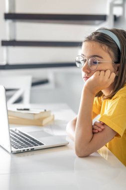 Sıkıcı öğrenci ödevlerini yaparken dizüstü bilgisayar kullanmaktan sıkılmış, üzgün genç kız sınav için hazırlanıyor..
