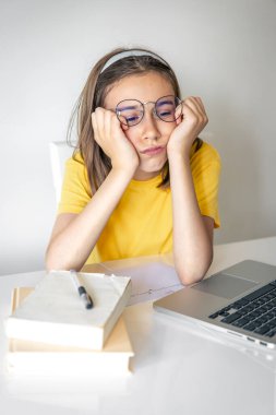 Sıkıcı öğrenci ödevlerini yaparken dizüstü bilgisayar kullanmaktan sıkılmış, üzgün genç kız sınav için hazırlanıyor..