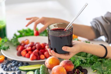 Bir bardak meyve suyu, meyveli ve sebzeli mutfak masasının arka planındaki meyveli ve meyveli meyveli meyveli meyve suyu..