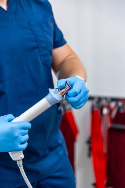 Şok dalgası terapi cihazı. Erkek doktor, lastik eldiven, manyetik alan, rehabilitasyon..
