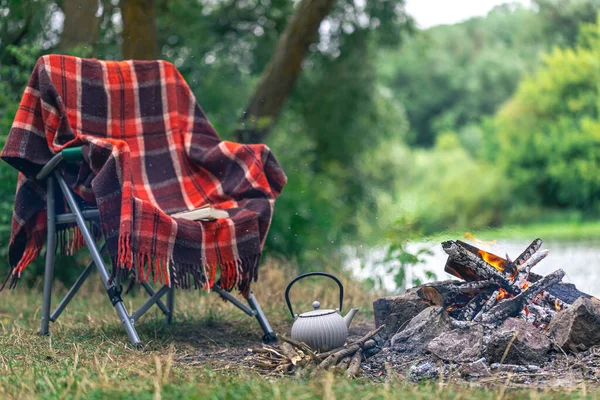 Small kettle is heated on a bonfire, hiking, travel, outdoor recreation concept.