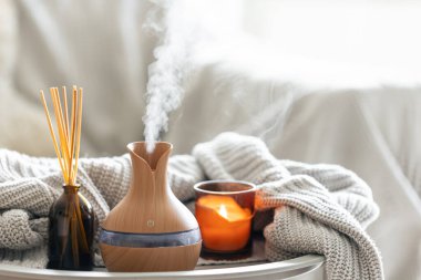 Çubuk parfümlü Aroma yağı yayıcı lamba, bulanık arkaplanda örülmüş element ve mum, boşluğu kopyala.