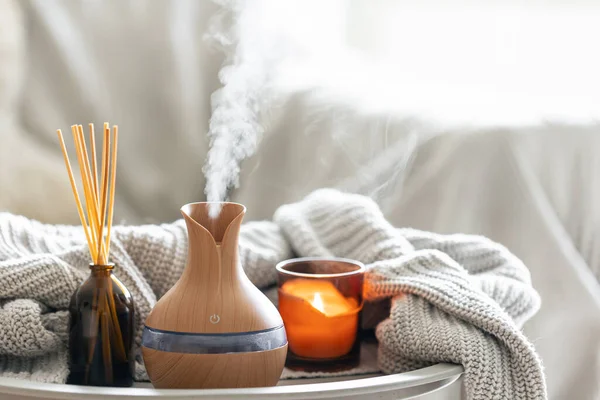 Çubuk parfümlü Aroma yağı yayıcı lamba, bulanık arkaplanda örülmüş element ve mum, boşluğu kopyala.