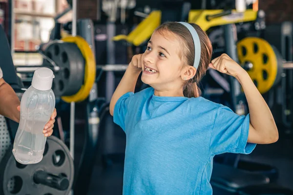 Urocza Dziewczynka Pokazuje Swoje Bicepsy Uśmiecha Się Podczas Treningu Siłowni — Zdjęcie stockowe