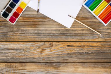 Ahşap arka planda boya ve fırçalı sanat paleti, yaratıcılık için iş yeri, ev öğretmenliği konsept çizimi, okul konseptine dönüş..