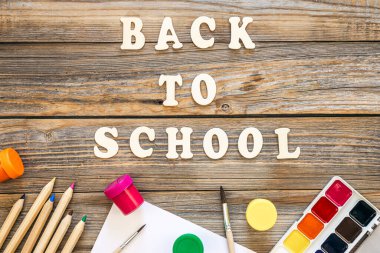 Renkli okul malzemeleri ve ahşap arka planda ahşap harfler. Okul konseptine geri dönüyoruz..