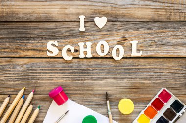 Renkli okul malzemeleri ve ahşap arka planda ahşap harfler. Okul konseptine geri dönüyoruz..