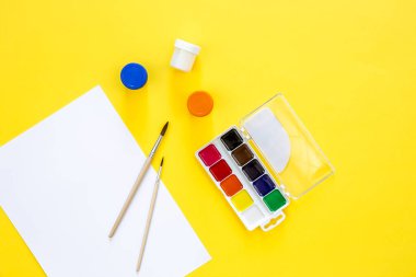 Sarı arka planda boya ve fırçalı sanat paleti, yaratıcılık işyeri, ev öğretmenliği konsept çizimi, okula dönüş konsepti..