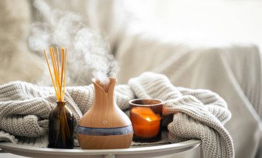 Çubuk parfümlü Aroma yağı yayıcı lamba, bulanık arkaplanda örülmüş element ve mum, boşluğu kopyala.