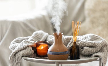 Çubuk parfümlü Aroma yağı yayıcı lamba, bulanık arkaplanda örülmüş element ve mum, boşluğu kopyala.