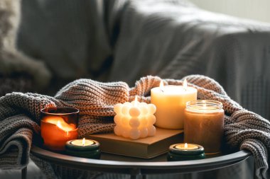 Yanan mumlar ve odanın iç kısmının bulanık arka planında örülmüş bir elementle dolu rahat bir hayat..