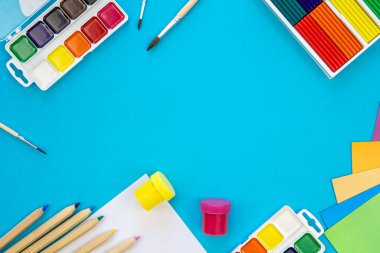 Mavi zemin üzerinde düz yatılı okul kırtasiyesi, okula geri dönüş konsepti, kopyalama alanı.