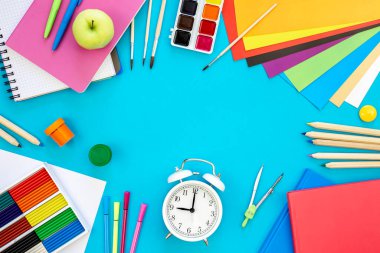 Mavi zemin üzerinde düz yatılı okul kırtasiyesi, okula geri dönüş konsepti, kopyalama alanı.