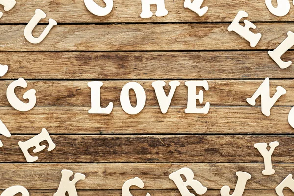 The word Love written on wood letters, text on wooden table for your design, top view concept.