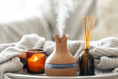 Çubuk parfümlü Aroma yağı yayıcı lamba, bulanık arkaplanda örülmüş element ve mum, boşluğu kopyala.