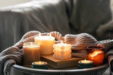 Yanan mumlar ve odanın iç kısmının bulanık arka planında örülmüş bir elementle dolu rahat bir hayat..