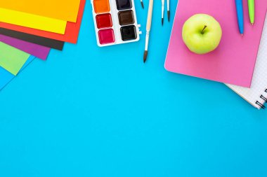 Mavi zemin üzerinde düz yatılı okul kırtasiyesi, okula geri dönüş konsepti, kopyalama alanı.