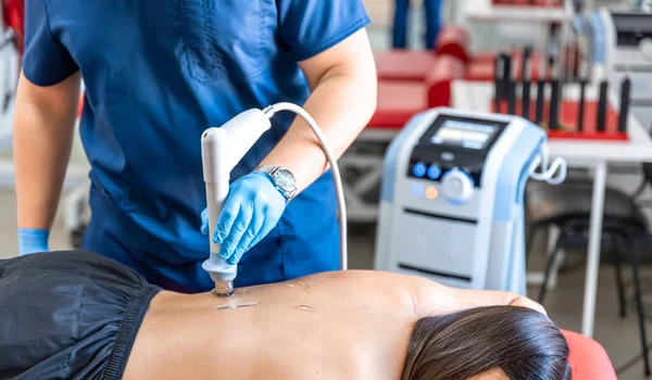 stock image Extracorporeal shockwave therapy, physical therapy for neck and back muscles, spine with shock waves, pain relief, normalization and regeneration,stimulation healing process.