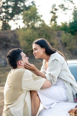 Güzel genç bir çift gün batımında çayırda piknik yapıyor, modaya uygun bir arabaya yaslanıyor, kadın ve erkek birbirlerinin keyfini çıkarıyorlar..