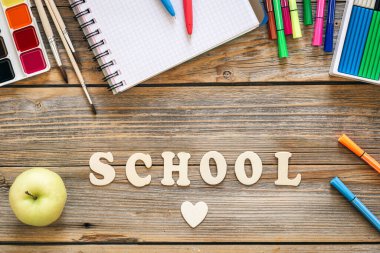 Okul kırtasiyesi, ahşap arka planda renkli malzemeler, üst manzara, okul konseptine geri dönüş..