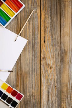 Ahşap arka planda boya ve fırçalı sanat paleti, yaratıcılık için iş yeri, ev öğretmenliği konsept çizimi, okul konseptine dönüş..