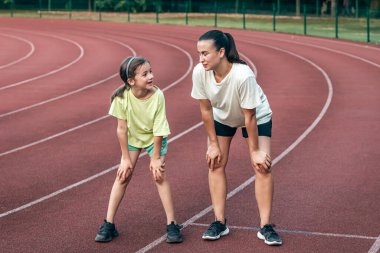 Antrenmandan sonra anne-kız stadyumda yorulmuş bir şekilde annesi ile birlikte formda kalıyor..