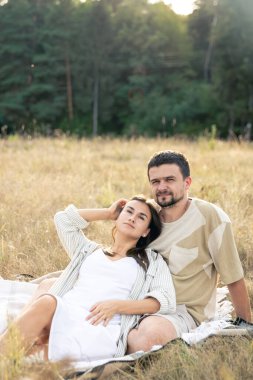 Mutlu evli erkek ve kadın, yazın bir tarlada rahatlıyor, birlikte kaliteli zaman geçiriyor, yakın ilişki, evlilikte romantizm..