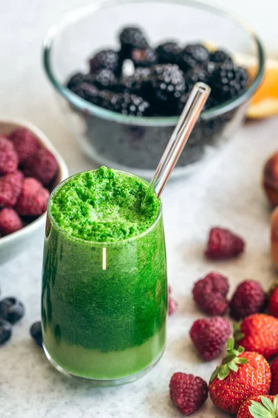 在模糊的厨房桌子上 放上一杯绿色冰沙 配上浆果 健康饮食 — 图库照片