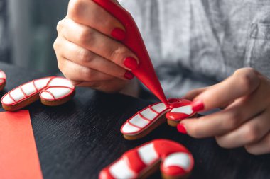 Zencefilli ekmeği lolipop şeklinde donduran bir kadın. Zencefilli kurabiye yapma kavramı..