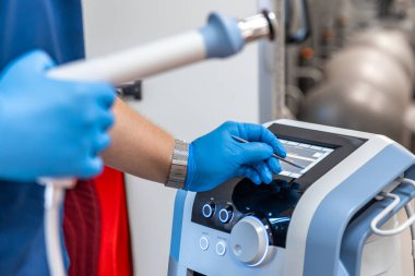 Şok dalgası terapi cihazı. Erkek doktor, lastik eldiven, manyetik alan, rehabilitasyon..