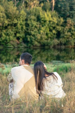 Kafkas aşıklar birlikte ve arkadan romantik göl manzarasına hayran kalıyorlar..