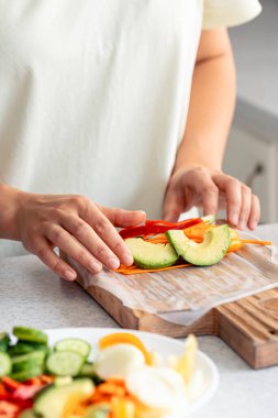 Kadınlar Çin böreğini taze sebzelerle, iştah açıcı diyet Asya yemekleriyle pişirir..