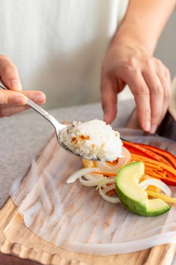 Kadınlar Çin böreğini taze sebzelerle, iştah açıcı diyet Asya yemekleriyle pişirir..