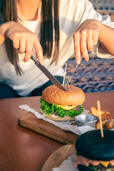 Μια Νεαρή Γυναίκα Τρώει Burger Στο Δρόμο Καφέ Κοντά Αμερικανικές — Φωτογραφία Αρχείου
