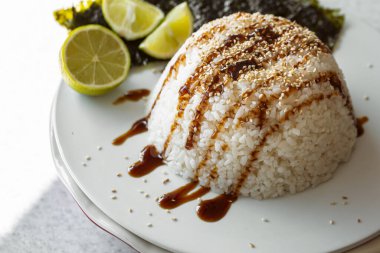 Yakın plan, üzerine sos ve susam tohumları serpiştirilmiş pirinç, Asya yemekleri konsepti, yemek için pirinç..