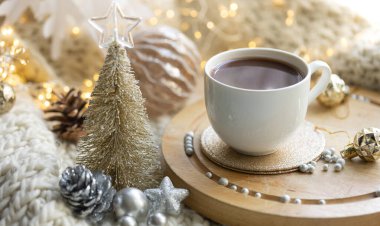 Kış kompozisyonu. Bir fincan kakao ve çikolatalı kurabiye. Arka planda bulanık ve Noel dekorlu..