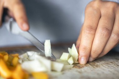 Bir kadın salata için kesme tahtasına sebze kesiyor..