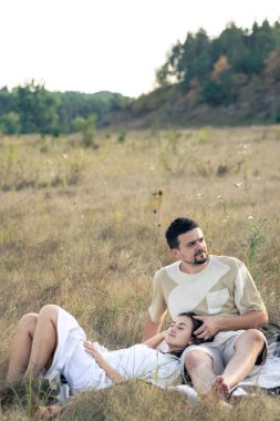 Mutlu evli bir adam ve kadın, yazın bir tarlada dinleniyorlar, birlikte kaliteli zaman geçiriyorlar, yakın ilişki, kopyalama alanı.
