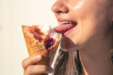 Genç bir kadın, sıcak bir yaz gününde gözleme külahında lezzetli dondurmalar yer..