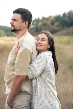 Olgun erkek ve kadının sahada dururken kucaklaşması, partnerle yakın ilişki, birlikte kaliteli zaman geçirmeleri..