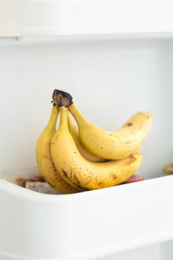Açık buzdolabı kabında muzların yakın çekimi, taze vitamin meyveli kahvaltı..