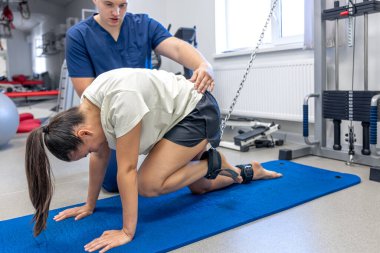 Kadınlar kas germek için egzersiz yapıyor, terapistler dolaptaki mekanik bozukluklara yardım ediyor..