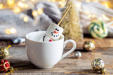 Sıcak çikolata kupası ve Noel kış süsleriyle marşmelovdan yapılmış kardan adam..