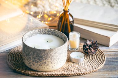 Sıcak kış kompozisyonu. Arka planda mumlar, kitaplar ve bokeh ışıkları var..