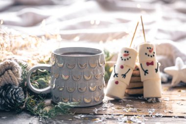 Bulanık arkaplanda bir fincan kakao ve marshmallow kardan adam ile kış kompozisyonu.