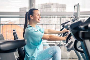 Spor salonunda kardiyo antrenmanı yapan bisikletli bir kadın spor salonunda egzersiz yapan genç bir kadın..
