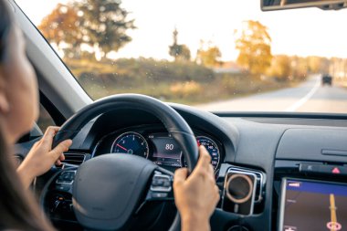 Çekici genç bir kadın araba kullanıyor, içeriden bakıyor, özel bir arabayla seyahat ediyor..