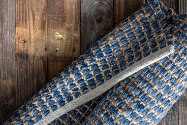 Ahşap zeminde el yapımı geometrik kot halısı, parça renkli halı, parlak hasır renkli halı..