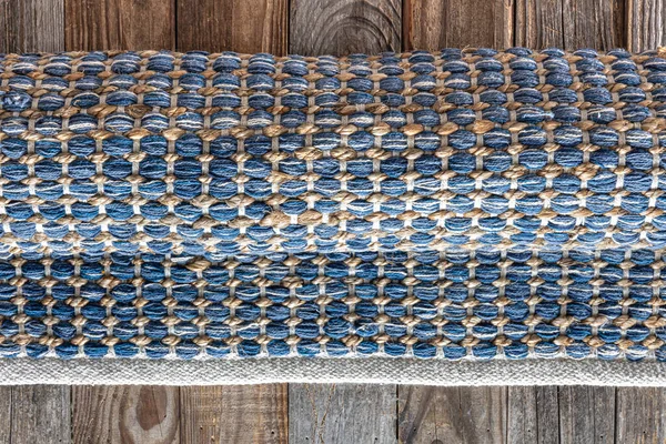 Ahşap zeminde el yapımı geometrik kot halısı, üst manzara..